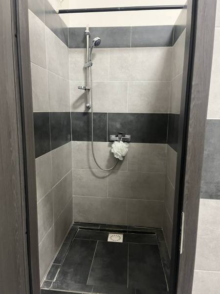 Exkluzívny obchodný priestor na prenájom v centre Dunajskej Stredy – u - Sprchový kút s čiernobielymi dlaždicami a kovovou sprchovou hlavicou v obchodných priestoroch.
