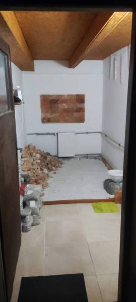 Kompletne zrekonštruovaný rodinný dom s wellness, bazénom a krásnou zá - Miestnosť v rodinnom dome s hromadou kameňov a bielymi stenami.