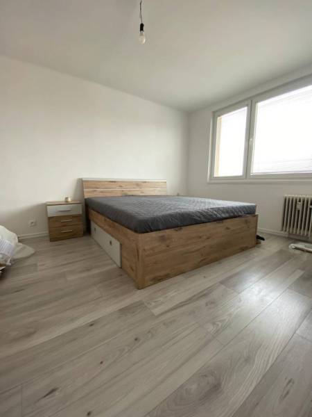 Na prenájom štýlový a moderný 2 izbový byt v centre Dunajskej Stredy - Spálňa v 2-izbovom byte s posteľou a podlahou s dreveným dekorom.