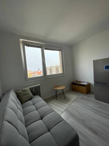 Na prenájom štýlový a moderný 2 izbový byt v centre Dunajskej Stredy - Obývacia miestnosť v 2-izbovom byte s gaučom, stolíkom a chladničkou.