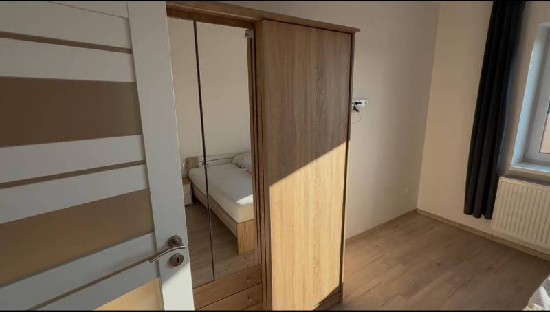 Prenájom 2-izbového bytu, Dunajská Streda - Spálňa v 2-izbovom byte s podlahou s dreveným dekorom a vstavanou skriňou.