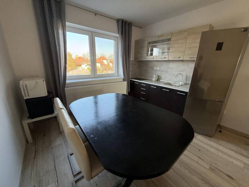 Prenájom 2-izbového bytu, Dunajská Streda - Kuchyňa v 2-izbovom byte s drezom, chladničkou a podlahou s dreveným dekorom.