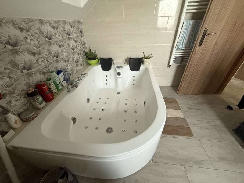 Predaj rodinného domu, Dunajská Streda - Kúpeľňa v rodinnom dome, s vírivkou a keramickými obkladačkami s dekorom kvetov.