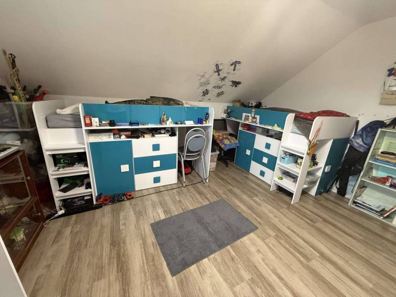 Predaj rodinného domu, Dunajská Streda - Izba v rodinnom dome s podlahou s dreveným dekorom, poschodovými posteľami a pracovnými stolmi.