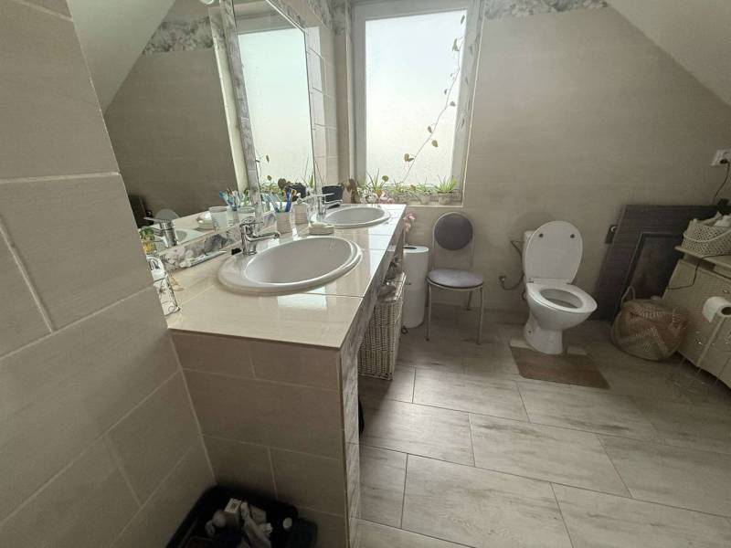 Predaj rodinného domu, Dunajská Streda - Kúpeľňa v rodinnom dome s dvojitým umývadlom a svetlou dlažbou.