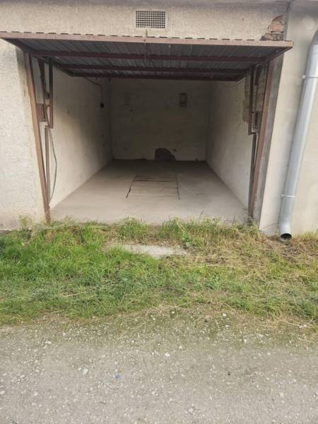 Predaj garáže, Nevädzová, Nevädzová, Dunajská Streda - Otvorená garáž s plechovou strechou, betónovou podlahou a oprýskanými stenami v Dunajskej Strede.