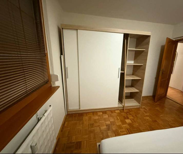 Prenájom 3-izbového bytu, Dunajská Streda - Spálňa v 3-izbovom byte s podlahou s dreveným dekorom a šatníkovou skriňou.