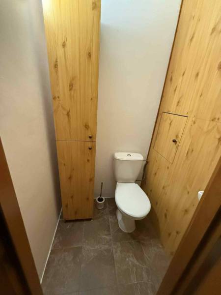 Prenájom 3-izbového bytu, Dunajská Streda - Toaleta v 3-izbovom byte so skrinkami z dreveným dekorom a bielym WC.
