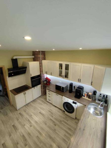 ☎️ 0918197701-Predám 3 izbový byt s loggiou po kompletnej rekonštrukci - Kuchyňa v 3-izbovom byte s bielymi skrinkami a podlahou s dreveným dekorom.