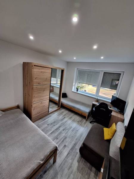 ☎️ 0918197701-Predám 3 izbový byt s loggiou po kompletnej rekonštrukci - Izba v 3-izbovom byte s podlahou s dreveným dekorom, posteľou a pracovným stolom.