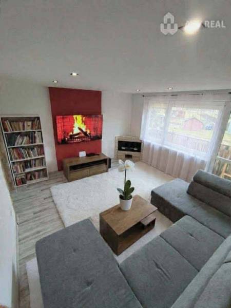 ☎️ 0918197701-Predám 3 izbový byt s loggiou po kompletnej rekonštrukci - Obývacia izba v 3-izbovom byte s podlahou s dreveným dekorom a pohodlnou sedačkou.