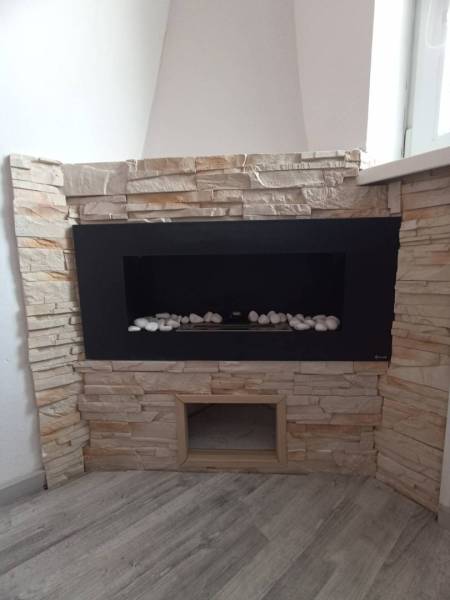 ☎️ 0918197701-Predám 3 izbový byt s loggiou po kompletnej rekonštrukci - Interiér 3-izbového bytu s krbom obloženým kamennými tvárnicami a podlahou s dreveným dekorom.