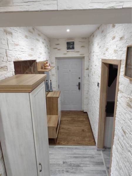 ☎️ 0918197701-Predám 3 izbový byt s loggiou po kompletnej rekonštrukci - Chodba s bielou tehlovou stenou a podlahou s dreveným dekorom v 3-izbovom byte.