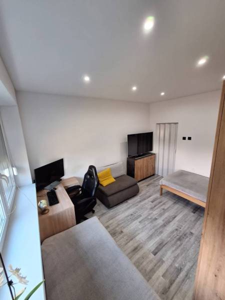 ☎️ 0918197701-Predám 3 izbový byt s loggiou po kompletnej rekonštrukci - Obývacia izba s pracovným kútom, televízorom a podlahou s dreveným dekorom v 3-izbovom byte.