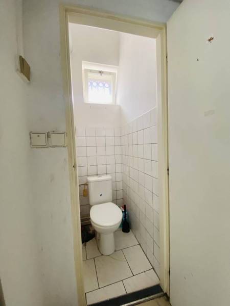 ☎️ 0918197701-Na prenájom obchodný priestor 30 m2 v centre mesta Dunaj - Toaleta s keramickými dlaždicami a malým oknom v obchodných priestoroch.