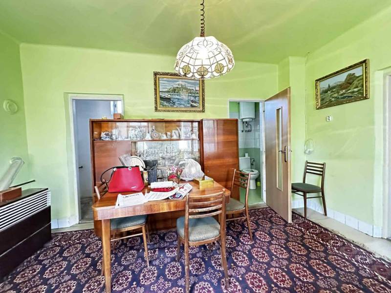 ☎️ 0918197701- Na predaj starší rodinný dom vhodný na kompletnú presta - Izba v rodinnom dome s nábytkom, zelenými stenami a kobercom.