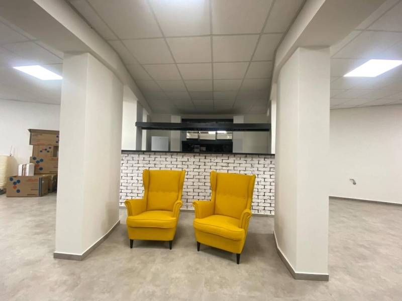 ☎️ 0918197701-Na prenájom väčší obchodný priestor 230 m² v suteréne v  - Obchodné priestory s dvoma žltými kreslami, bielou tehlovou stenou a krabicami.