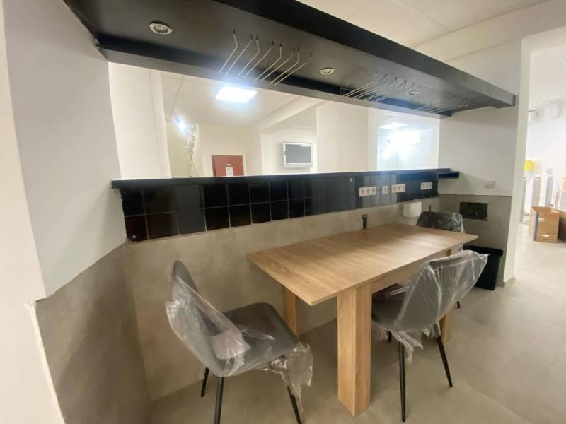 ☎️ 0918197701-Na prenájom väčší obchodný priestor 230 m² v suteréne v  - Obchodné priestory s podlahou s dreveným dekorom, stôl a stoličky pokryté fóliou.