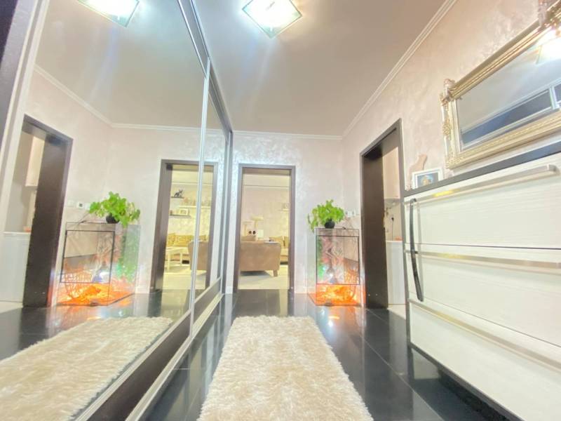 ☎️ 0918197701- 296 900, - € Znížená cena   !!!Na predaj krásny, štýlov - Interiér rodinného domu so zrkadlovou skriňou, rastlinou a bielym kobercom na tmavej podlahe.