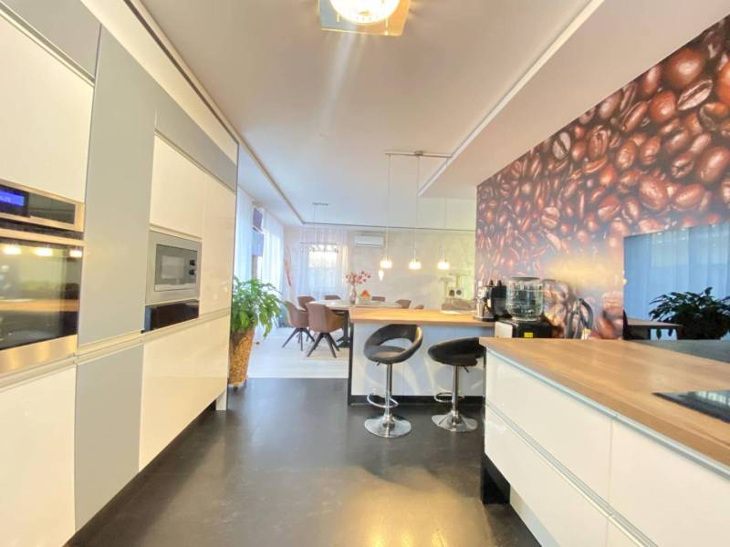 ☎️ 0918197701- 296 900, - € Znížená cena   !!!Na predaj krásny, štýlov - Kuchyňa v rodinnom dome so stolom, barovými stoličkami a stenou s motívom kávových zŕn.