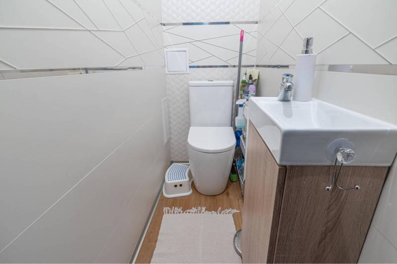 ☎️ 0918197701-Na predaj 5 izbový poschodový rodinný dom s 2 garážou v  - Kompaktná kúpeľňa v rodinnom dome s umývadlom, WC a podlahou s dreveným dekorom.