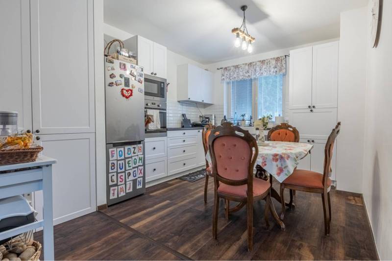 ☎️ 0918197701-Na predaj 5 izbový poschodový rodinný dom s 2 garážou v  - Kuchyňa v rodinnom dome s podlahou s dreveným dekorom, vintage stoličky, biela linka.