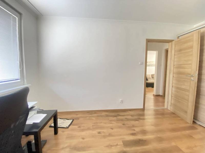 REZERVOVANÉ   0918197701- Výrazná zľava NA PREDAJ  kompletne  zariaden - Biela izba s podlahou s dreveným dekorom, kancelárskym stolom a dverami do 3-izbového bytu.