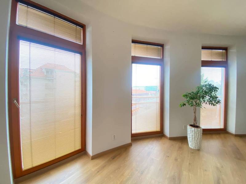 ☎️ 0918197701   Na predaj  elegantný 3 izbový byt priamo v centre Duna - Svetlá izba s tromi vysokými oknami a podlahou s dreveným dekorom v 3-izbovom byte.