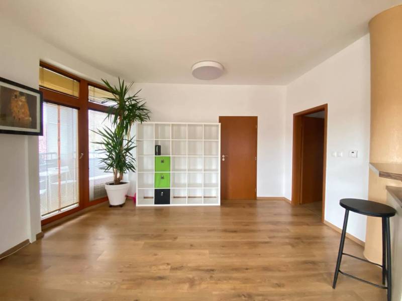 ☎️ 0918197701   Na predaj  elegantný 3 izbový byt priamo v centre Duna - Obývacia izba v 3-izbovom byte s podlahou s dreveným dekorom a bielou policovou skriňou.