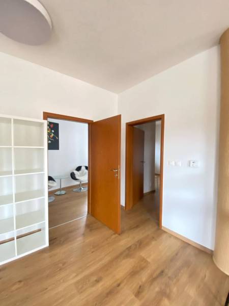 ☎️ 0918197701   Na predaj  elegantný 3 izbový byt priamo v centre Duna - Interiér 3-izbového bytu s podlahou s dreveným dekorom a bielou knižnicou.