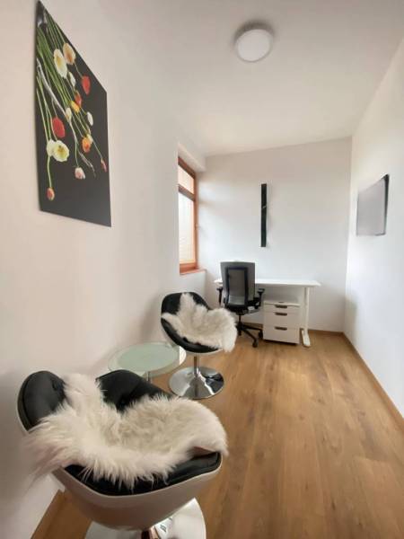 ☎️ 0918197701   Na predaj  elegantný 3 izbový byt priamo v centre Duna - Pracovňa v 3-izbovom byte s podlahou s dreveným dekorom, kreslami a stolom.