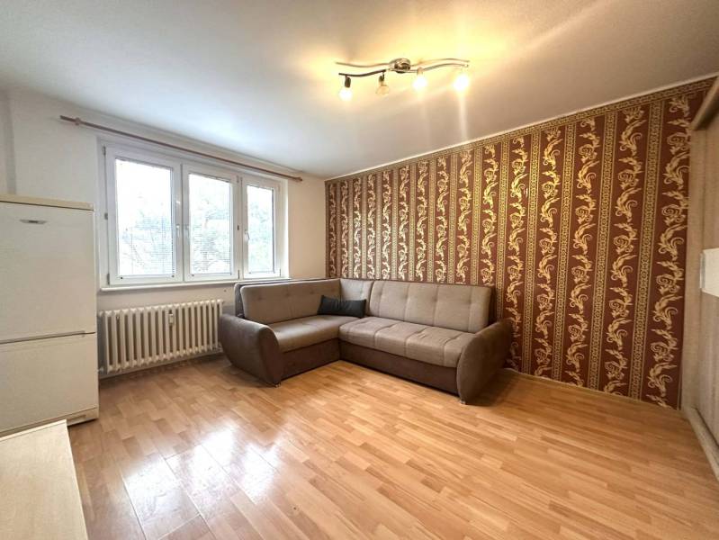 REZERVOVANÉ  ☎️ 0918/197 701 Na prenájom garsónka blízkosti centra mes - Rekreačný apartmán s pohodlnou sedačkou, tapetovanou stenou a podlahou s dreveným dekorom.