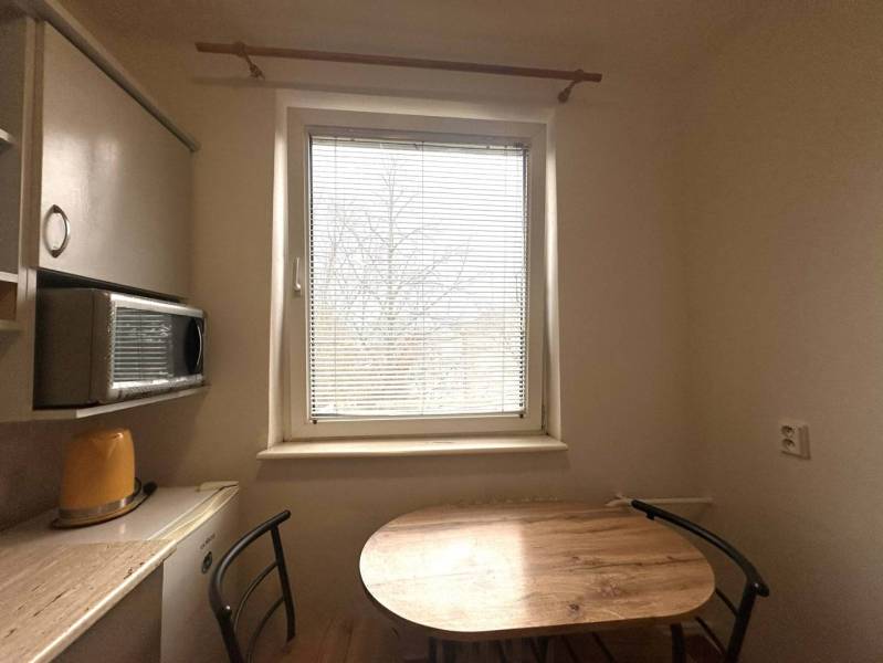 REZERVOVANÉ  ☎️ 0918/197 701 Na prenájom garsónka blízkosti centra mes - Kuchyňa v rekreačnom apartmáne s oknom a stolom s dreveným dekorom.