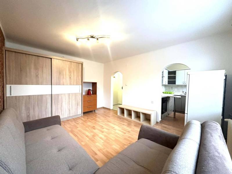 REZERVOVANÉ  ☎️ 0918/197 701 Na prenájom garsónka blízkosti centra mes - Rekreačný apartmán so sedačkou, podlahou s dreveným dekorom, kuchyňou a skriňou na uloženie vecí.