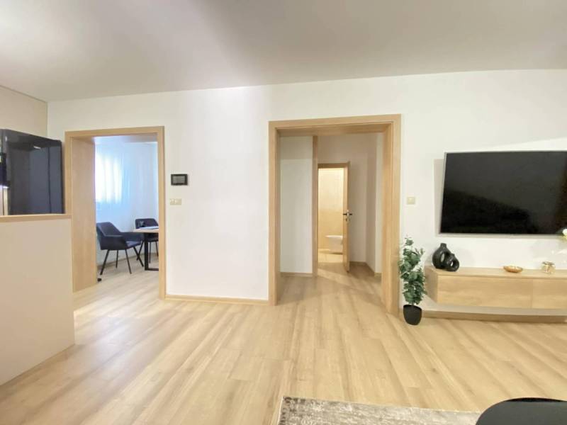 ☎️ 0918/197 701 Predám priestranný  3 izbový  byt s veľkou terasou a m - Interiér 3-izbového bytu s podlahou s dreveným dekorom a televízorom na stene.