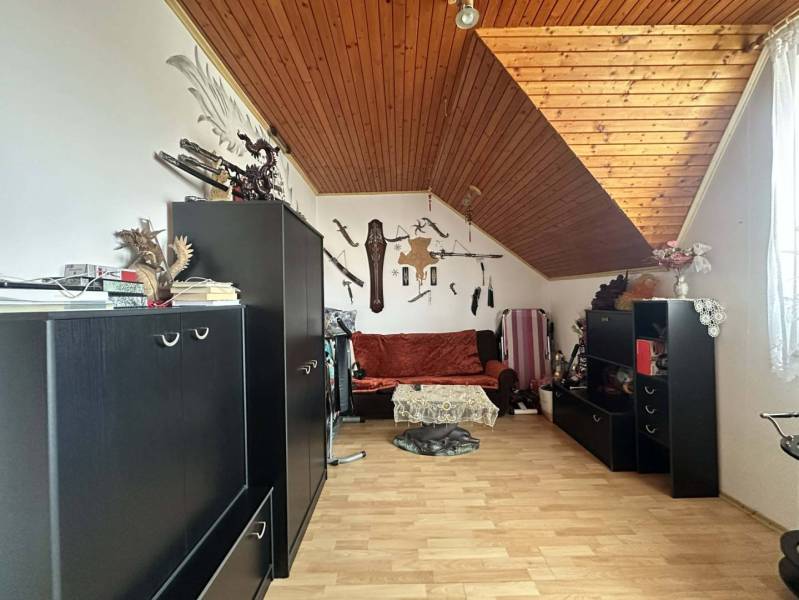 ☎️0918197701   Na predaj 2 generačný,  8 izbový poschodový dom s dvoma - Podkrovná miestnosť s dekorom zbraní, čiernym nábytkom a podlahou s dreveným dekorom.