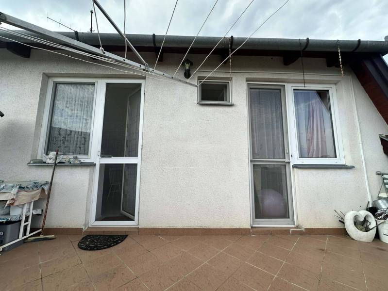 ☎️0918197701   Na predaj 2 generačný,  8 izbový poschodový dom s dvoma - Exteriér rodinného domu v Šamoríne s bielou fasádou a dlažbou na dvore.