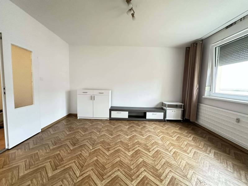 ☎️  0918/197 701  Na prenájom 1 izbový byt s balkónom a pivnicou v mes - Izba s podlahou s dreveným dekorom, bielym nábytkom a veľkým oknom v 1-izbovom byte.