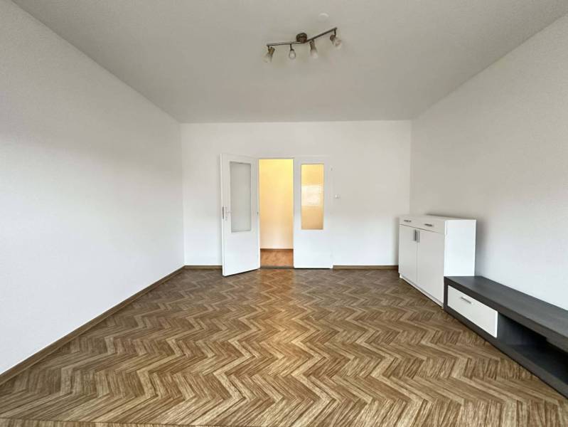 ☎️  0918/197 701  Na prenájom 1 izbový byt s balkónom a pivnicou v mes - Priestranná izba v 1-izbovom byte s podlahou s dreveným dekorom a bielym nábytkom.