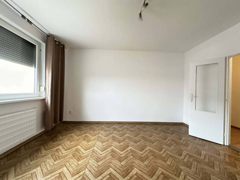 ☎️  0918/197 701  Na prenájom 1 izbový byt s balkónom a pivnicou v mes - Miestnosť s podlahou s dreveným dekorom v 1-izbovom byte, závesom a oknom.