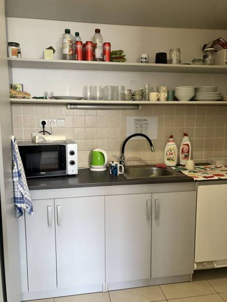 ☎️0911 234 656 Prenájom obchodný priestor v centre mesta Dunajská Stre - Kuchynka v obchodných priestoroch s mikrovlnkou, umývadlom a policami plnými riadu.