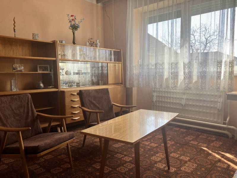 0911 234 656 Predaj rodinný dom v obci Jahodná - Obývacia izba v rodinnom dome s retro nábytkom, záclonami a zdobeným kobercom.