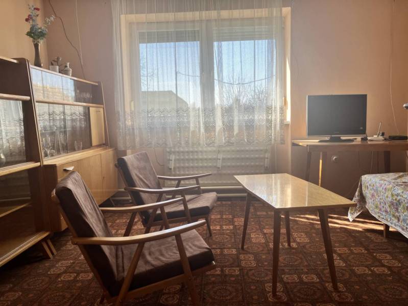 0911 234 656 Predaj rodinný dom v obci Jahodná - Obývacia izba v rodinnom dome s retro nábytkom a televízorom, kvetinová dekorácia.