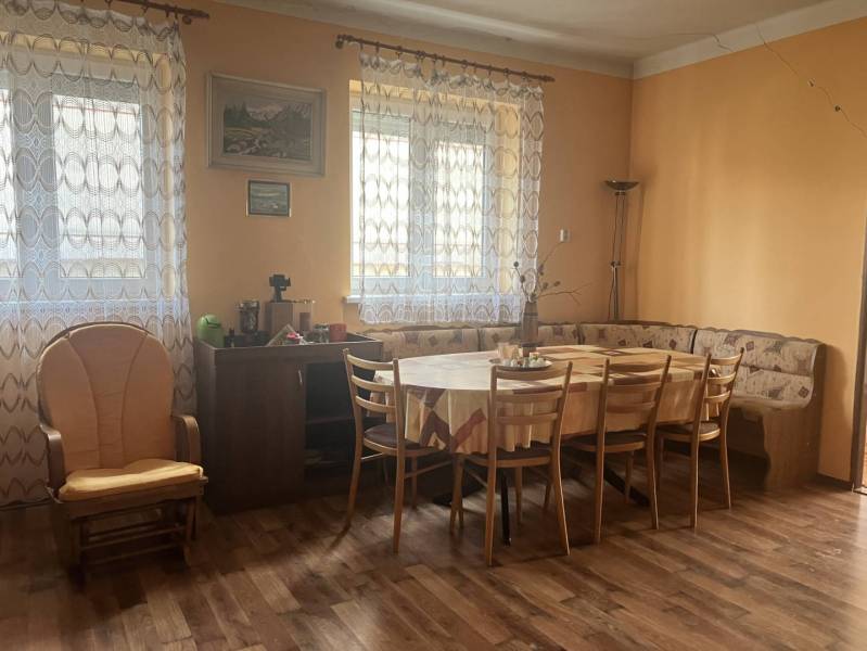 0911 234 656 Predaj rodinný dom v obci Jahodná - Jedálenský kút s rohovou lavicou, kreslom, stolom a podlahou s dreveným dekorom v rodinnom dome.