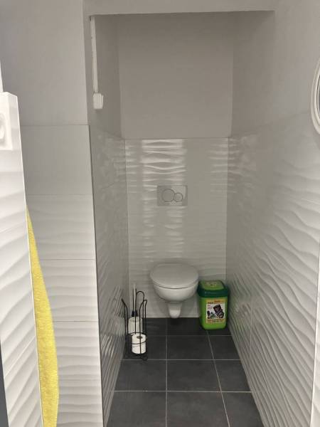 0911 234 656 Prenájom obchodný priestor v centre mesta - Toaleta v obchodných priestoroch s bielymi obkladmi a čiernou podlahou.