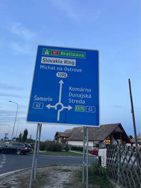 ZNÍŽENÁ CENA! Stavebný pozemok o rozlohe 557 m2 v Holiciach! - Dopravná značka smerujúca na rôzne destinácie vrátane Slovakia Ringu a Bratislavy.