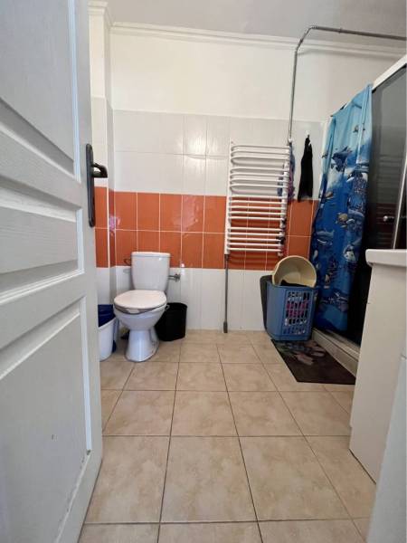 ZNÍŽENÁ CENA!!! Apartmánový dom na predaj vo Veľkom Mederi - Kúpeľňa v rodinnom dome s oranžovými obkladmi, toaletou a sprchovým kútom.