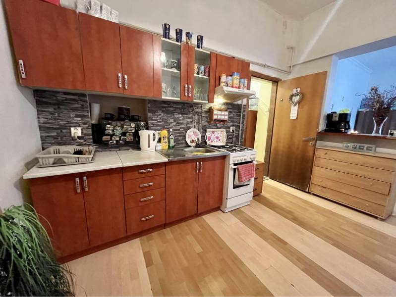 ZNÍŽENÁ CENA!!! Apartmánový dom na predaj vo Veľkom Mederi - Kuchyňa v rodinnom dome s podlahou s dreveným dekorom, kuchynskými skrinkami a spotrebičmi.