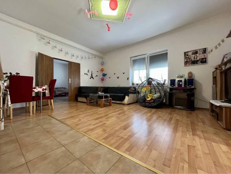 ZNÍŽENÁ CENA!!! Apartmánový dom na predaj vo Veľkom Mederi - Obývacia izba v rodinnom dome s podlahou s dreveným dekorom, jedálenským kútom a gaučom.