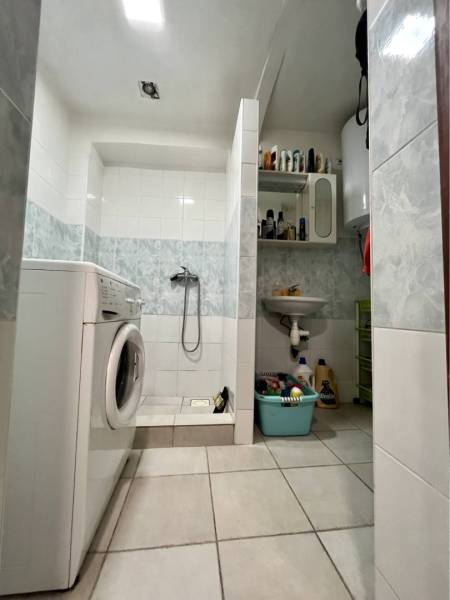 ZNÍŽENÁ CENA!!! Apartmánový dom na predaj vo Veľkom Mederi - Kúpeľňa v rodinnom dome s práčkou, sprchovým kútom a úložnými policami.